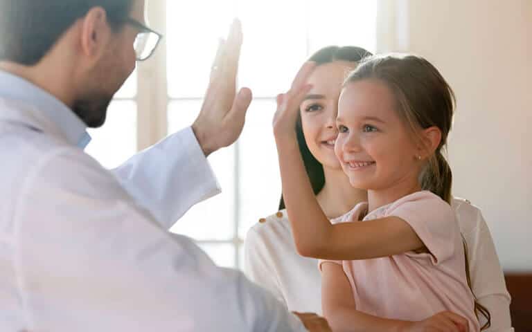 Young girl giving a high five to a doctor