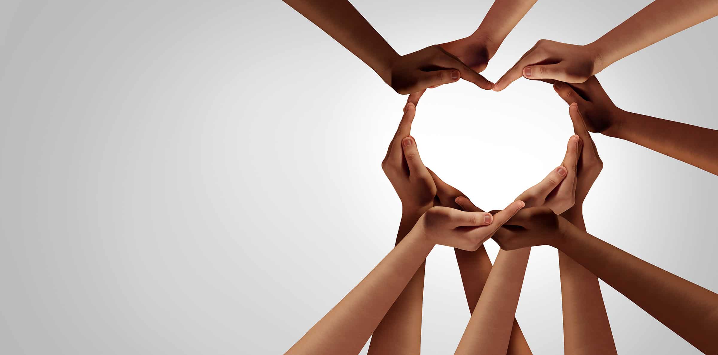 Several hands forming the shape of a heart.