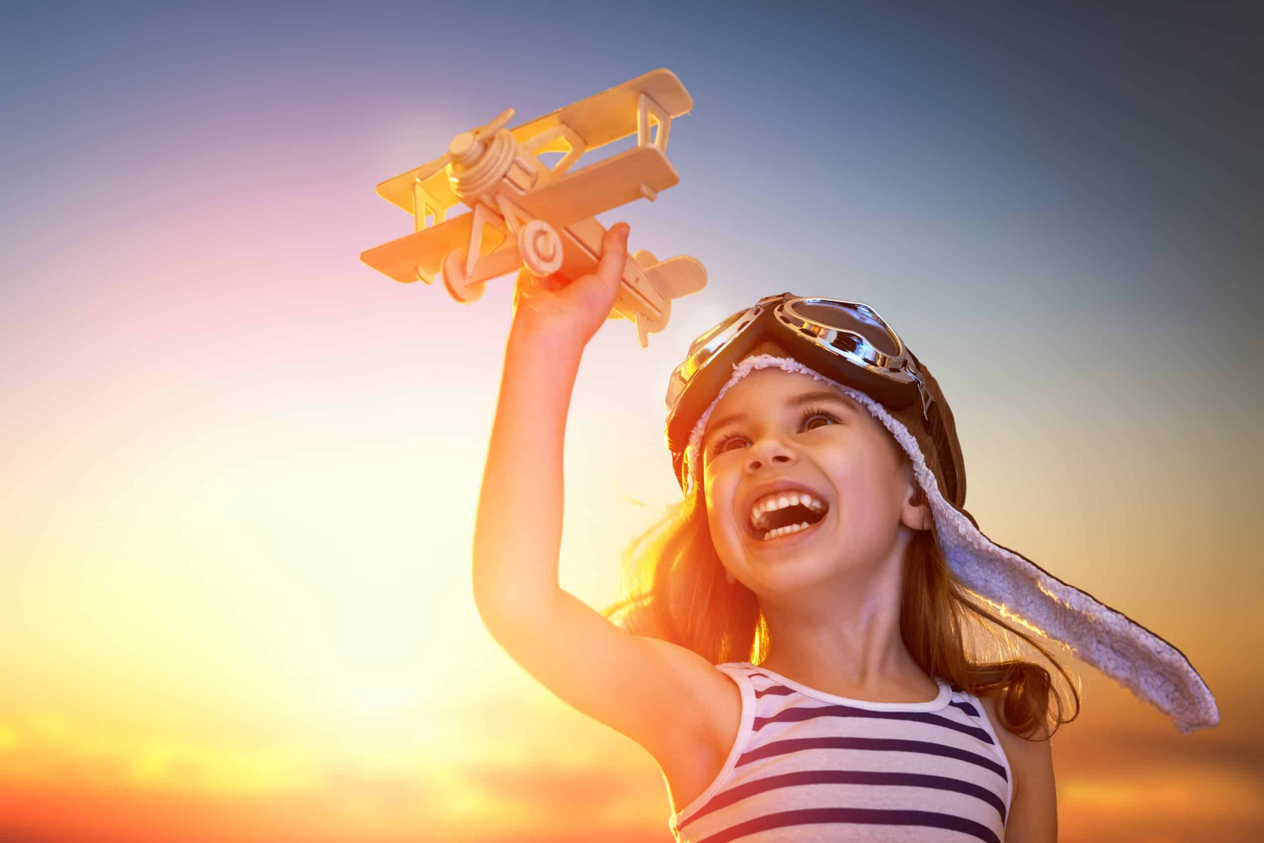 Smiling child playing with a toy airplane